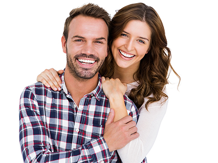 The image shows a man and a woman embracing each other with smiles on their faces, both dressed casually, against a white background.